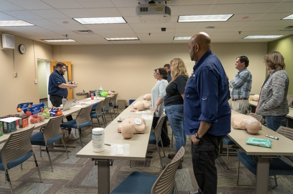 Associates in a classroom learning CPR